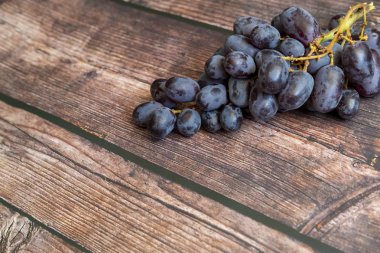 Tahta masanın üstünde tohumsuz kırmızı üzüm..