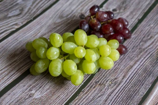 Rote und gelbe kernlose Trauben auf dem Holztisch bereit zum Servieren. — Stockfoto