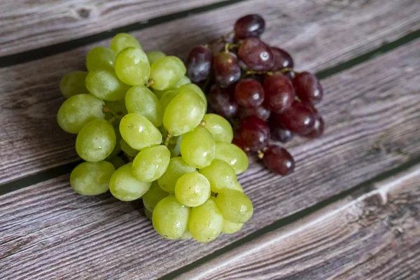 Rote und gelbe kernlose Trauben auf dem Holztisch bereit zum Servieren. — Stockfoto