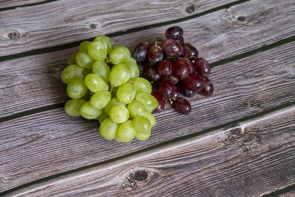 Rote und gelbe kernlose Trauben auf dem Holztisch bereit zum Servieren. — Stockfoto