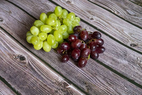 Uva roja y amarilla sin semillas en la parte superior de la mesa de madera lista para servir . — Foto de Stock