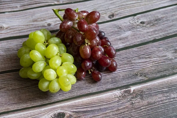 Rote und gelbe kernlose Trauben auf dem Holztisch bereit zum Servieren. — Stockfoto