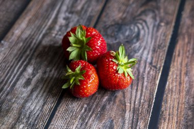 Tahta masanın üstünde taze kırmızı İskoç çilekleri..