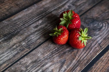 Tahta masanın üstünde taze İngiliz çilekleri servis edilmeye hazır..