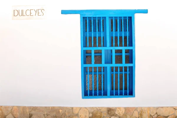 Facade of a colonial style blue window in Villa de Leyva, Colombia.