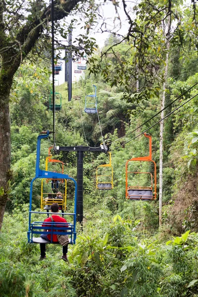 MANIZALES, COLOMBIA - JUNE 1: Unidentified people ride the brightly painted ski lifts through the jungle at the Recinto del Pensamiento nature reserve near Manizales, Colombia on June 1, 2016.