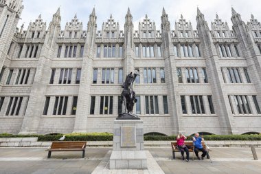 Aberdeen, İngiltere - 3 Ağustos: Kimliği belirsiz kişi yanındaki Robert Bruce heykel Aberdeen, Amerika Birleşik Devletleri tarihinde 3 Ağustos 2016 üniversitede Marischal önünde otur..