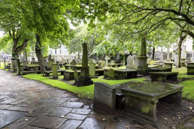 Islak yol ve Kirk, Saint Nicholas Uniting Aberdeen, İskoçya'da, eski mezar taşları. 