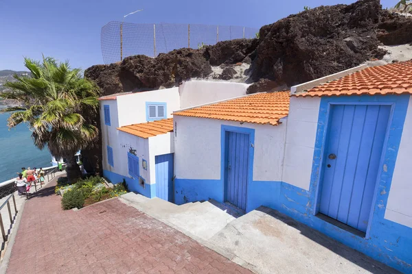 Beautiful white and blue houses built around volcanic rock in Sao Martinho in Madeira, Portugal.