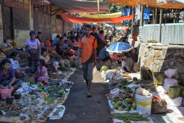 MAUMERE, INDONESIA - MAY 9: An unidentified man walks towards the camera at the primary market in Maumere, Indonesia on May 9, 2017. clipart