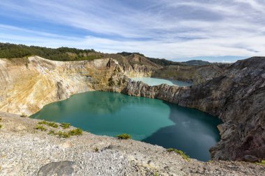 Danau Kootainuamuri crater and the Danau Alapolo lake in the foreground at Kelimutu National Park in Indonesia.  clipart
