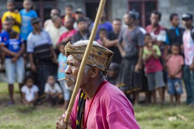 BAJAWA, INDONESIA - MAY 19: An unidentified elder performs traditional dancing at a boxing match near Bajawa in East Nusa Tenggara, Indonesia on May 19, 2017.  clipart