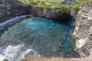 Nusa Penida sahilde kırık ve Akuamarin Mavi suya bakarak. 