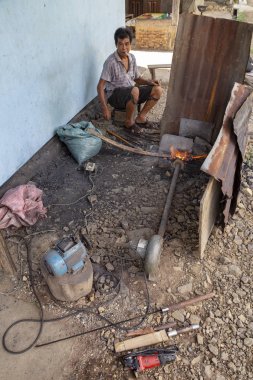 Luang Prabang, Laos - 8 Ekim: Kimliği belirsiz itibariyle yerel köy forge Luang Prabang, Laos üzerinde 8 Ekim 2017 yılında kömürlerin kıpırdanırken.