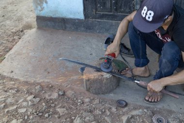 Luang Prabang, Laos - 8 Ekim: Kimliği belirsiz bir demirhane Luang Prabang, Laos üzerinde 8 Ekim 2017 yılında bir kılıca biler.