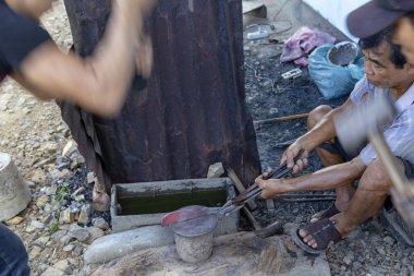 Luang Prabang, Laos - 8 Ekim: Kimliği belirsiz bir köy demirhane Luang Prabang, Laos 8 Ekim 2017 tarih içinde bir bıçak uydurandan.