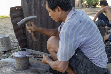Luang Prabang, Laos - 8 Ekim: Kimliği belirsiz bir kırmızı sıcak bıçak Luang Prabang, Laos üzerinde 8 Ekim 2017 yılında köy demirhane, çekiç.