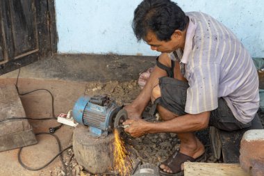 Luang Prabang, Laos - 8 Ekim: Kimliği belirsiz bir köy demirhane Luang Prabang, Laos 8 Ekim 2017 tarih içinde bir bıçak biler.