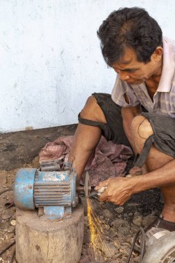 Luang Prabang, Laos - 8 Ekim: Luang Prabang, Laos üzerinde 8 Ekim 2017 yılında köy demirhane bir bıçağa kimliği belirsiz şekiller.