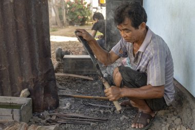 Luang Prabang, Laos - 8 Ekim: Kimliği belirsiz bir tutamaç Luang Prabang, Laos üzerinde 8 Ekim 2017 yılında köy demirhane içine bir bıçak tang yakar.