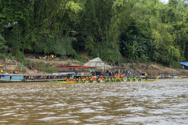 Luang Prabang, Laos - 4 Ekim: Kimliği belirsiz kişi turuncu giymiş ve Budist bir ucundaki yeşil yarış tekne yarışı Luang Prabang, Laos üzerinde 4 Ekim 2017 yılında ödünç.
