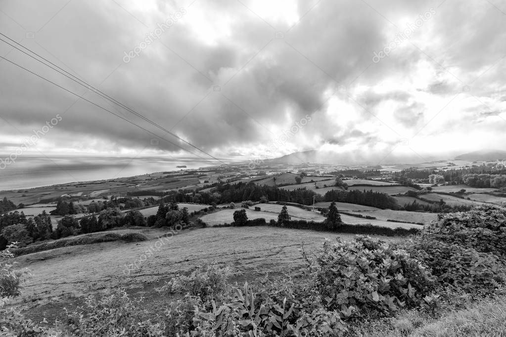 Black and view of pasture land above the towns of Vila Franca do Campo and Ribeira Seca on Sao Miguel, Azores.