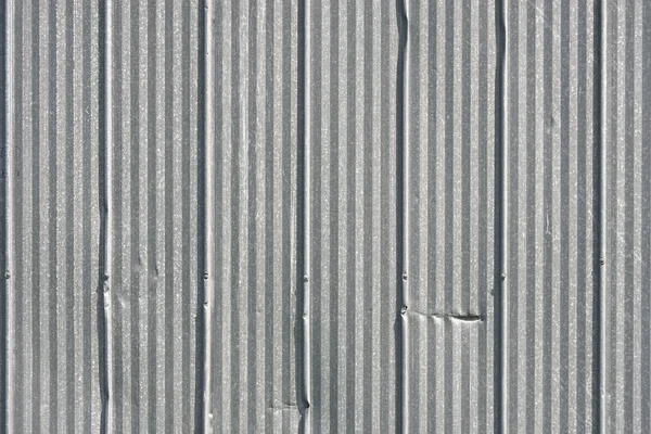 An abstract image of an old corrugated sheet metal wall.