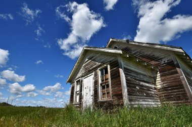 Yıpranmış ve çiftlik parlak mavi gökyüzü altında aşağı koşmak eski bir görüntüsünü.