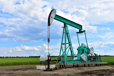 Bulutlu bir günde bir çalışma petrol kuyusu pompa jakına bir görüntü. 