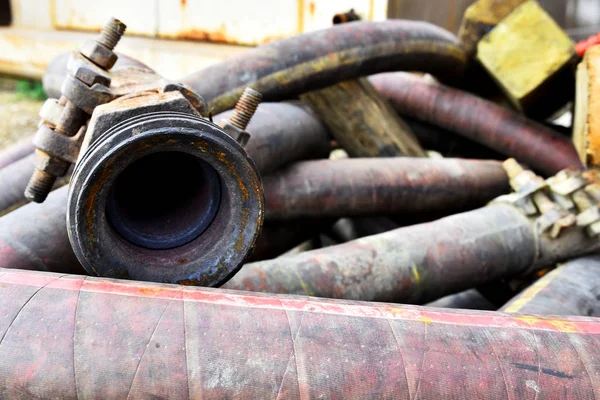 An abstract image of old rusted industrial hoses and hoses connectors.