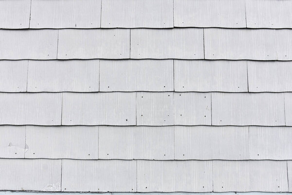 An abstract image of white wooden tiles on a building exterior.