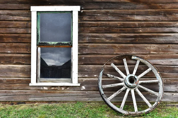丸太小屋にもたれて古い木製のワゴン ホイールのイメージ — ストック写真