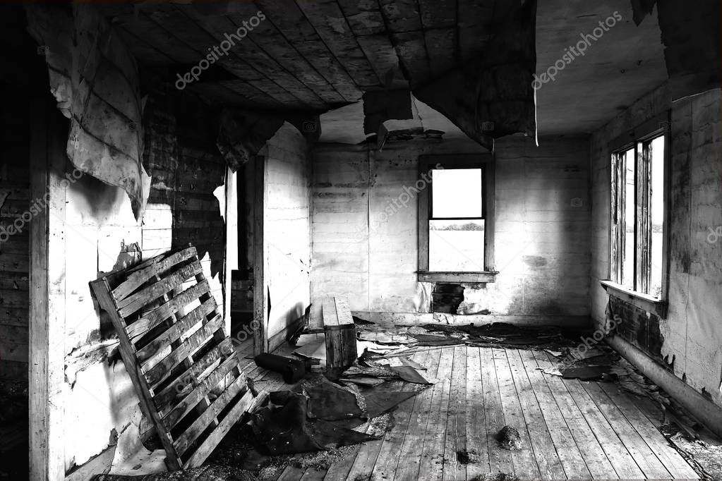 A black and white image of the creepy interior of an old abandoned house. 