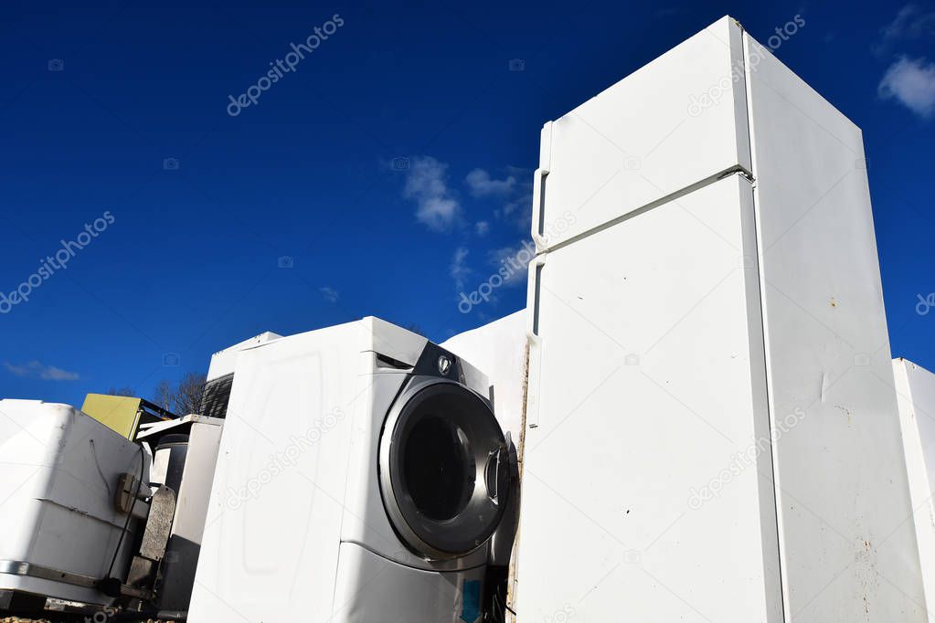 An image of several old and used appliances at a recycling facility. 