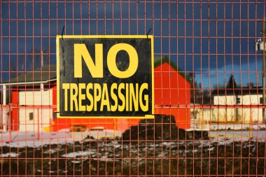 Bir açık kazı sitesi çevreleyen bir zincir bağlantı çit üzerinde yayınlanan bir haneye tecavüz iz yok görüntüsünü. 