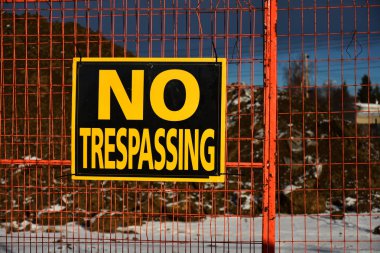 Bir açık kazı sitesi çevreleyen bir zincir bağlantı çit üzerinde yayınlanan bir haneye tecavüz iz yok görüntüsünü. 