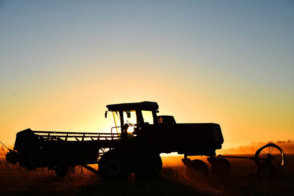 Силуэт комбайна на сеновале на закате солнца
. 
