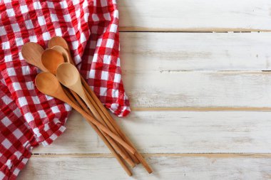 Kırmızı ve beyaz kareli masa örtüsü üzerinde birkaç tahta kaşıklar üstten görünüm görüntüsünü. 