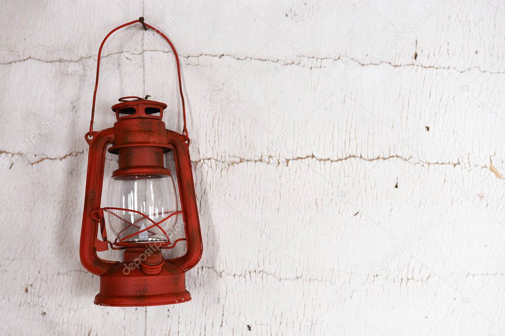 A close up image of an old vintage red lantern in a run down building. 