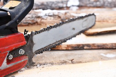 Görüntü bir eski kırmızı chainsaw ve kesme yakacak odun yakından. 