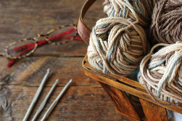 Крупный план вязальной пряжи и крючков для вязания на старинном деревянном столе
. 