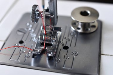 Parlak kırmızı iplik dikiş makinesi iğneyle görüntüsünü yakından. 