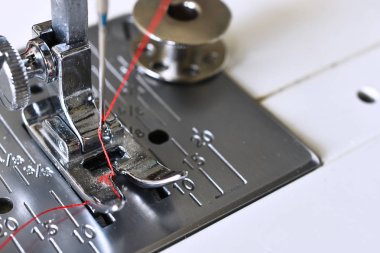 Parlak kırmızı iplik dikiş makinesi iğneyle görüntüsünü yakından. 