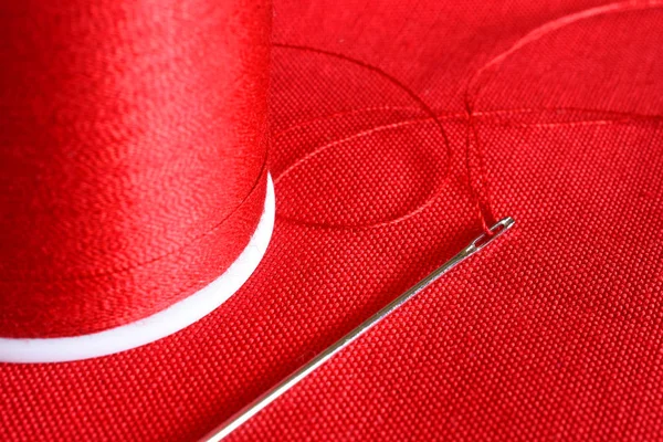 Uma Imagem Perto Carretel Linha Vermelha Agulha Costura Tecido Vermelho — Fotografia de Stock