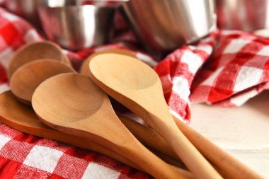 Rustik bir mutfakta çeşitli ahşap karıştırma kaşığı ve kalay ölçme bardakları yakın bir görüntü. 