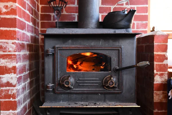 An image of an old wood burning stove with cast iron antique kettle.