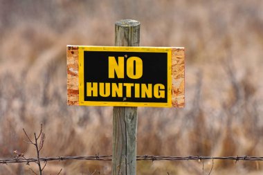 Ahşap bir çit direğine izinsiz giriş işareti parlak sarı bir görüntü. 