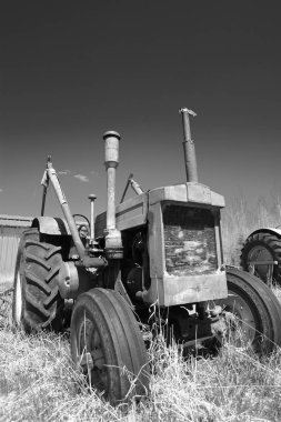 Eski bir çiftlik traktöraşağı çalıştırmak siyah beyaz görüntü. 