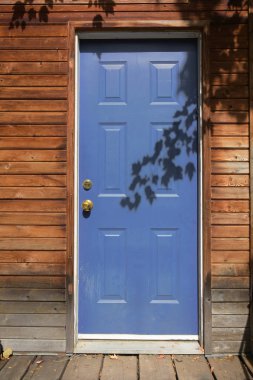 Kırsal bir kır evindeki eski bir mavi metal dış kapının görüntüsü..