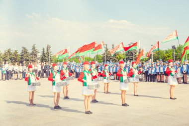 Minsk, Beyaz Rusya - 1 Mayıs 2017: Öğrenciler-öncü öncü Kravatlar ile olay kabul töreni için öncüleri için selam söyle. Ellerinde kırmızı bayraklar.